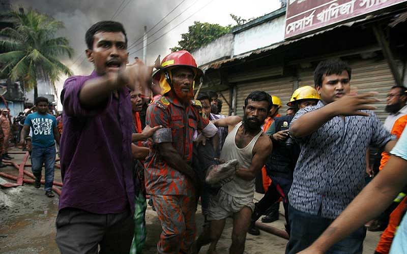 A Bangladeshi rescue worker and a volunteer carry the body of a victim from the site of an explosion in a factory in the key Bangladeshi garment manufacturing town of Tongi, just north of the capital Dhaka, on September 10, 2016. Photo: AFP