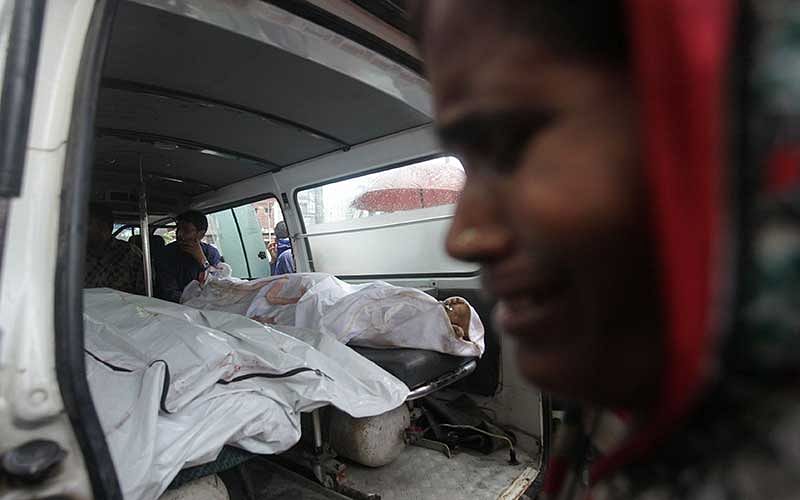A mourner cries next to the bodies of factory workers in a vehicle after an explosion in a factory in the key Bangladeshi garment manufacturing town of Tongi, just north of the capital Dhaka, on September 10, 2016. Photo: AFP