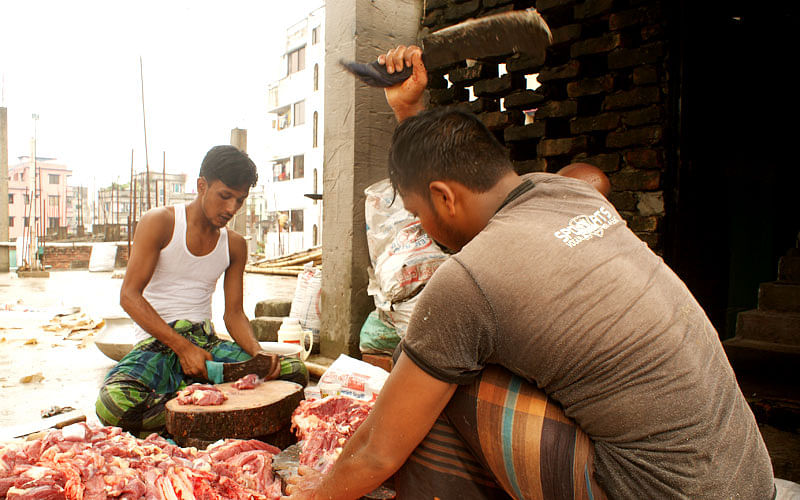 Kamal, a tea vendor in occupation who turns ‘seasonal butcher’ on Eid-ul-Azha, in action with teammates. Photo: Imam Hossain