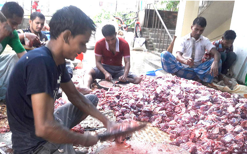Munna Koshai with his five-man team busy chopping meat on Eid day, Tuesday. Photo: Naeem Rahman