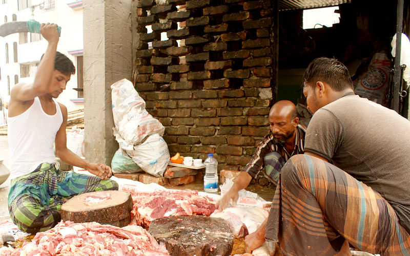 Kamal, a tea vendor in occupation who turns ‘seasonal butcher’ on Eid-ul-Azha, in action with teammates. Photo: Imam Hossain