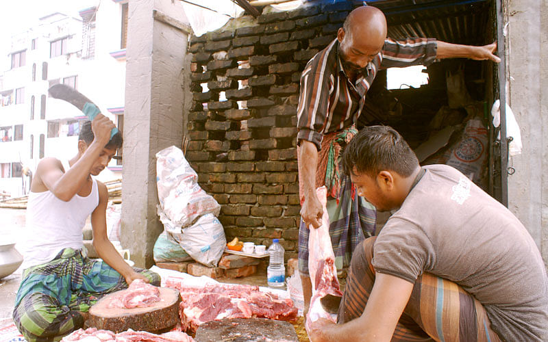 Kamal, a tea vendor in occupation who turns ‘seasonal butcher’ on Eid-ul-Azha, in action with teammates. Photo: Imam Hossain