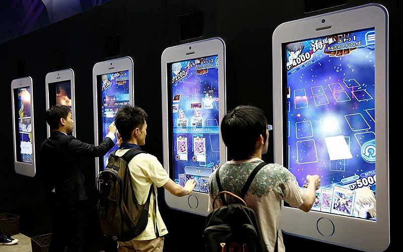 People play video games on mobile phone-shaped screens at Tokyo Game Show 2016 in Chiba, east of Tokyo, Japan. Photo : Reuters