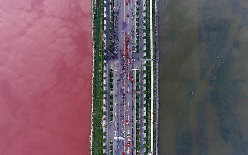 A salt lake which is separated by a road, shows parts of it in different colours due to algae, in Yuncheng, Shanxi Province, China, September 25, 2016. Reuters