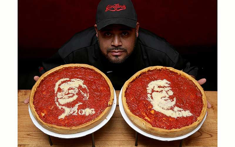 Head cook Fabian Martinez poses with pizza`s decorated with the images of U.S. Democratic presidential nominee Hillary Clinton (L) and Republican presidential nominee Donald Trump at Giordano`s Pizzeria in Chicago, Illinois, U.S., September 27, 2016. Reuters