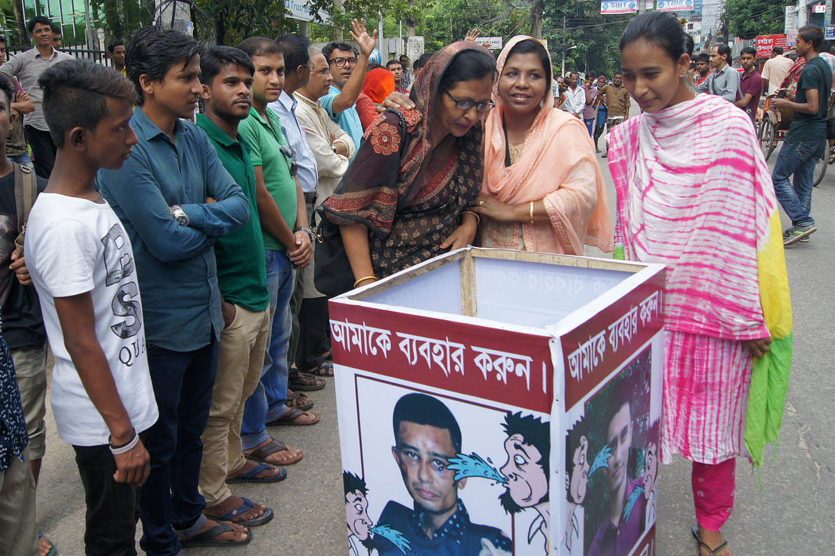 People spit on portraits of Bangladesh Chhatra League leader Badrul Alam at the Sylhet Central Shaheed Minar on Tuesday. Photo: Prothom Alo