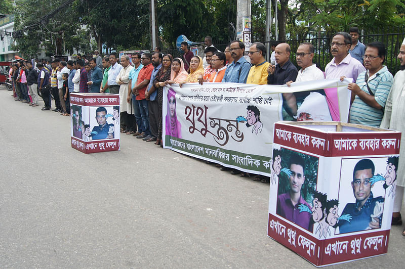 People spit on portraits of Bangladesh Chhatra League leader Badrul Alam at the Sylhet Central Shaheed Minar on Tuesday. Photo: Prothom Alo