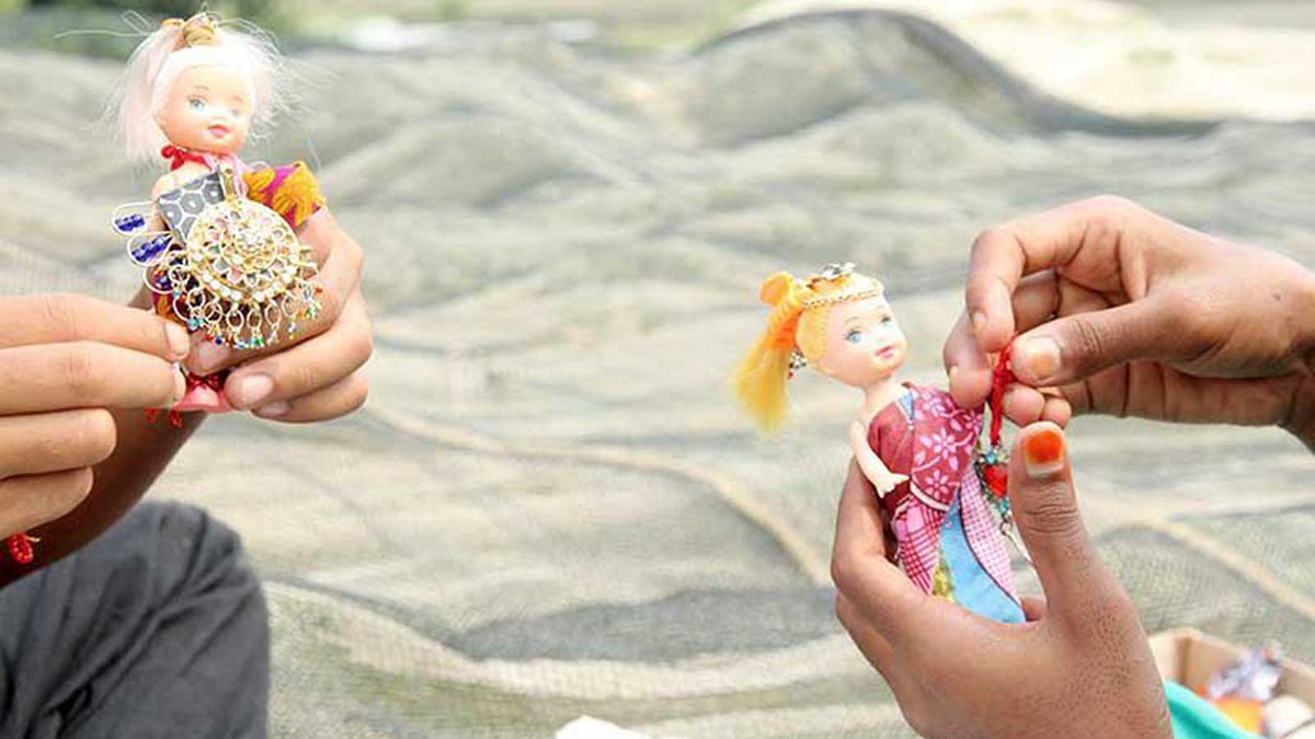 The children use discarded pieces of jewellery to decorate their dolls.  Photo: Soyel Rana