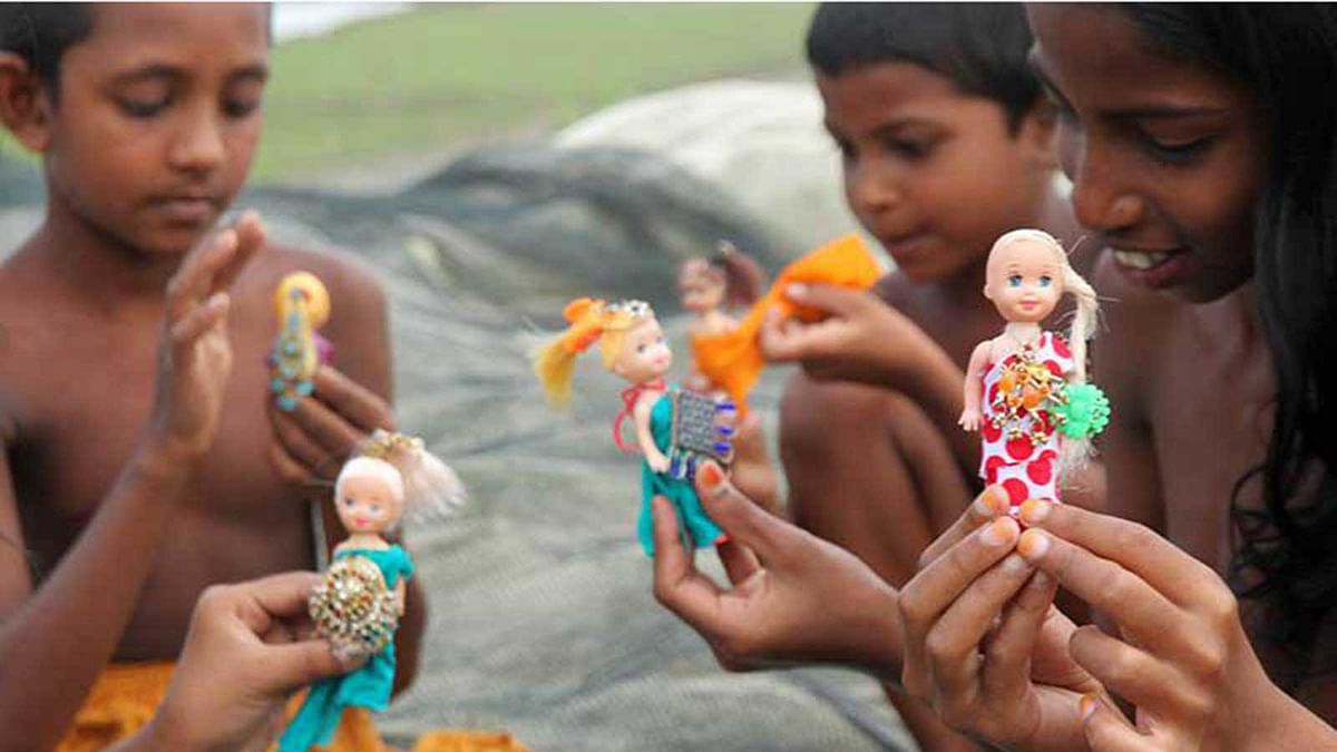 Homeless children play with tiny dolls near the Jamuna river. Photo: Soyel Rana