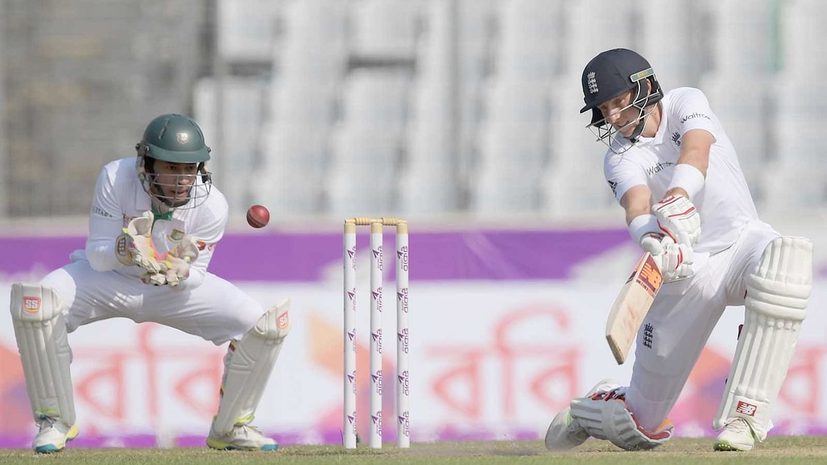 England`s Joe Root plays a shot as Bangladeshi captain Mushfiqur Rahim looks on during the second day of the second Test cricket match between Bangladesh and England on 29 October. Photo: AFP