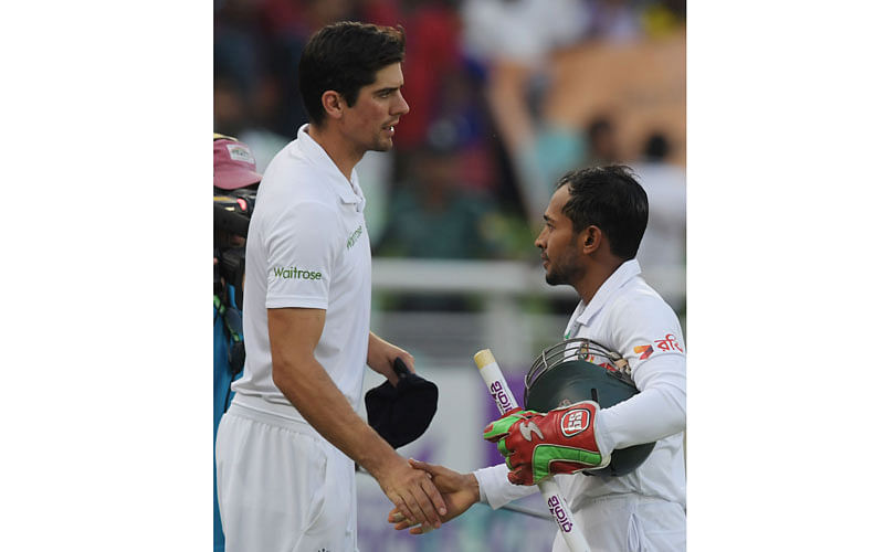 Mushfiqur Rahim (R) shakes hands with England captain Alastair Cook at the Sher-e-Bangla National Cricket Stadium in Dhaka on 30 October. Photo: AFP