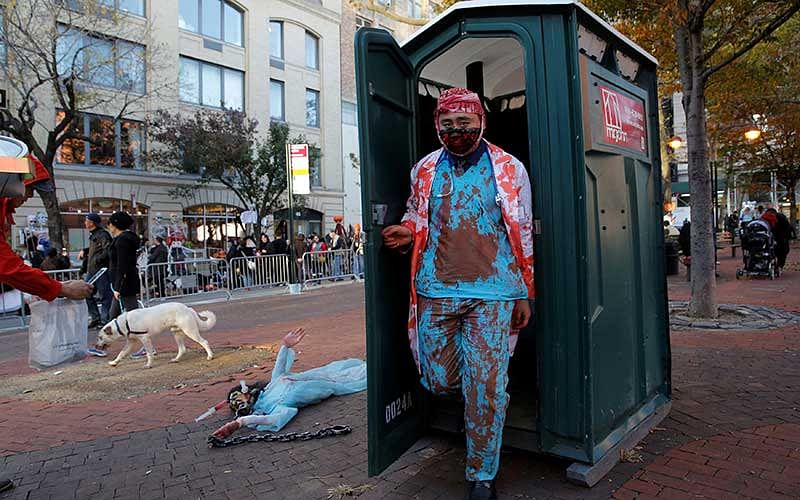 A man in costume exits a portable restroom before participating in the Greenwich Village Halloween Parade in Manhattan, New York. Photo: Reuters
