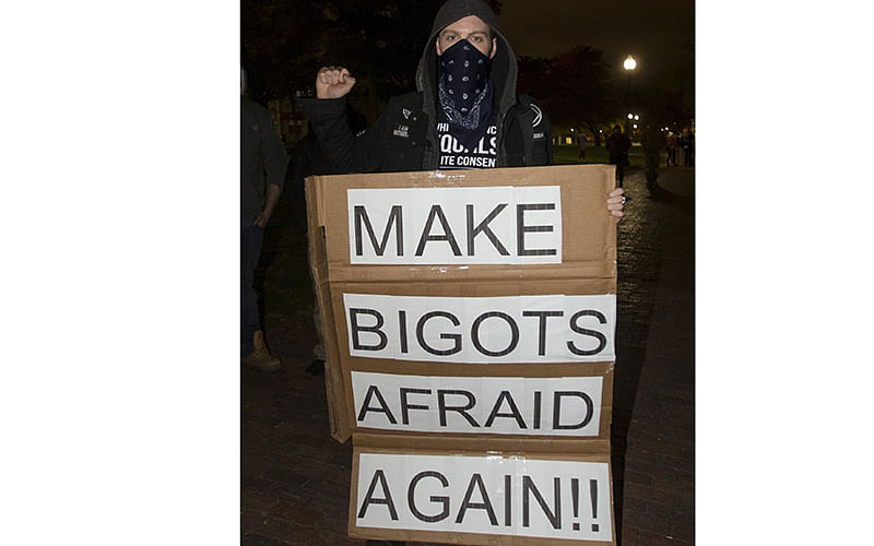 A protester holds a sign reading `Make Bigots Afraid Again` during a protest against the elction of Donald Trump in the Boston Common on November 9, 2016 in Boston, Massachusetts. Trump defeated Democrat Hillary Clinton in an upset to become the 45th president. Photo: AFP