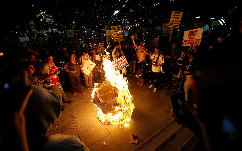 A Donald Trump pinata is burned by people protesting the election of Republican Donald Trump as the president of the United States in downtown Los Angeles, California U.S., November 9, 2016. Photo: Reuters