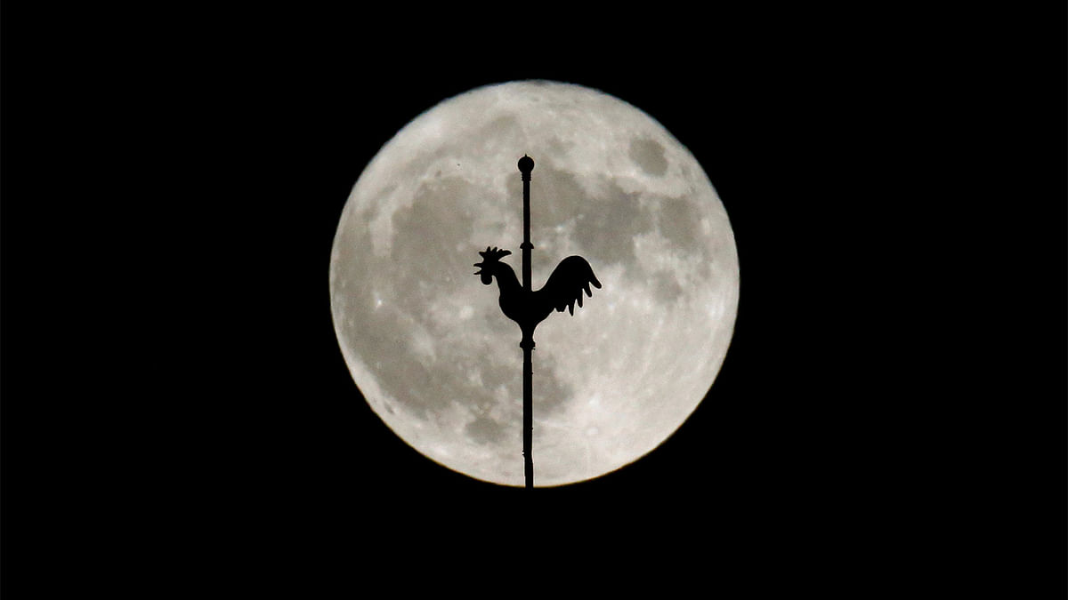 The rising supermoon is seen behind the weathercock of the church of Saint-Hilaire in the village of Saint-Fiacre-sur-Maine near Nantes. Reuters