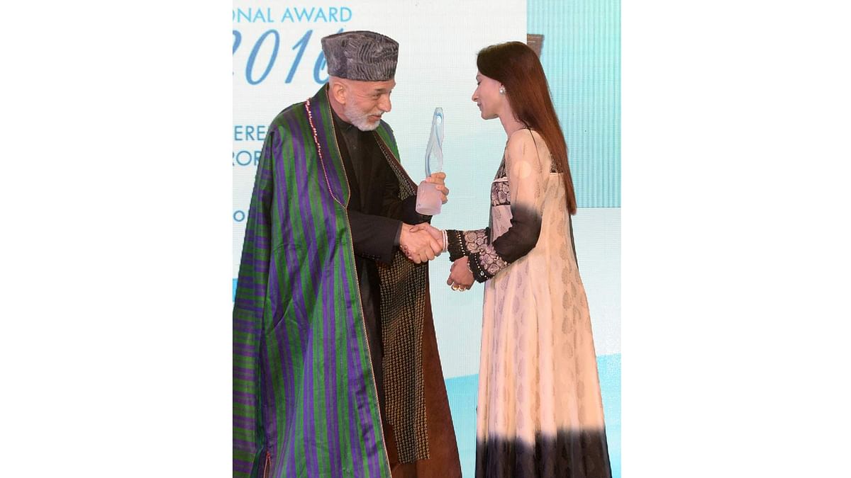 Simeen Hossain (R) receives the Mother Teresa Memorial International Award for Social Justice 2016 from former Afghan President Hamid Karzai, on behalf of her martyred son Faraaz Ayaaz Hossain at an award ceremony in Mumbai on 20 November 2016. Photo: AFP