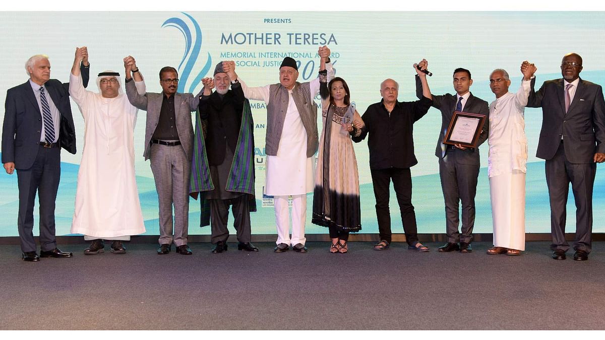 Simeen Hossain (6thL), her elder son Zaraif (3rdR), former Afghan president Hamid Karzai (4thL), former Jammu and Kashmir chief minister Farooq Abdullah (5thL), Indian film director Mahesh Bhatt (4thR) and other dignitaries are pictured after Simeem Hossain received the Mother Teresa Memorial International Award for Social Justice 2016, on behalf of her son Faraaz Ayaaz Hossain at an award ceremony in Mumbai on 20 November 2016.  Photo: AFP