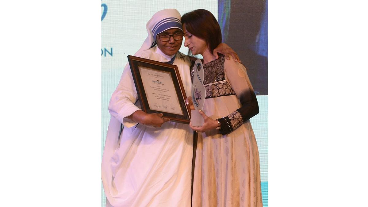 Simeen Hossain (R)receives the Mother Teresa Memorial International Award for Social Justice 2016 from from Sister Priscila of Missionaries of Charity, on behalf of her martyred son Faraaz Ayaaz Hossain at an award ceremony in Mumbai on 20 November 2016. Photo: AFP