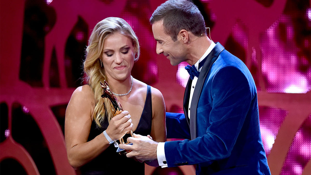 German Tennis player Angelique Kerber receives the Bambi award from TV host Kai Pflaume on November 17, 2016 in Berlin. The Bambis are the main German media awards. Photo: AFP