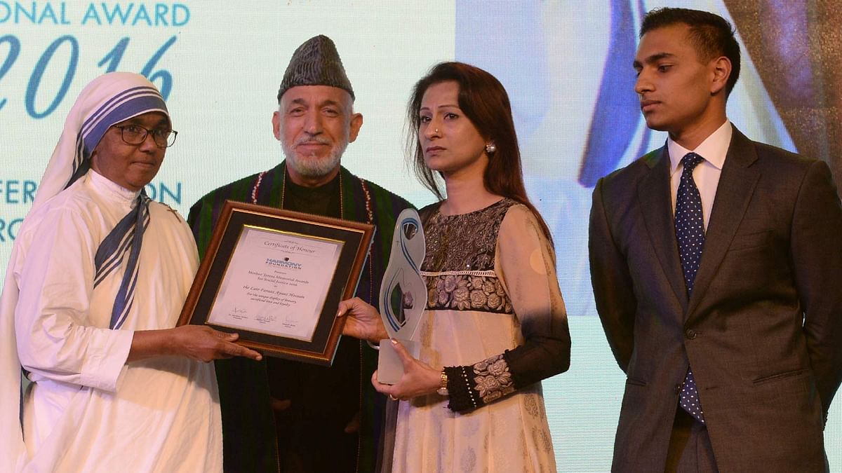 Simeen Hossain (2R) watched by her elder son Zaraif (R) receives the Mother Teresa Memorial International Awards for Social Justice from former President of Afghanistan, Hamid Karzai (2L), on behalf of her martyred son Faraaz Ayaaz Hossain at an award ceremony in Mumbai on 20 November 2016.  Photo: AFP