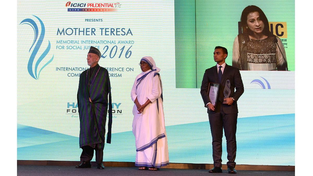 (From L) Former Afghan president Hamid Karzai, Sister Priscila of Missionaries of Charity and Zaraif Hossain, watch Zaraif`s mother Simeen Hossain (Rear on screen) speaking after receiving the Mother Teresa Memorial International Award for Social Justice 2016, on behalf of her martyred son Faraaz Ayaaz Hossain. Photo: AFP