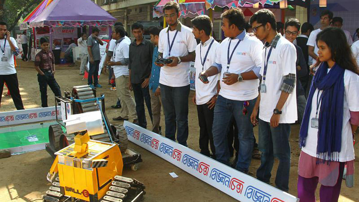 Employees of the Gyanchinta magazine use controllers to display a robot for festival attendees. Photo: Prothom Alo