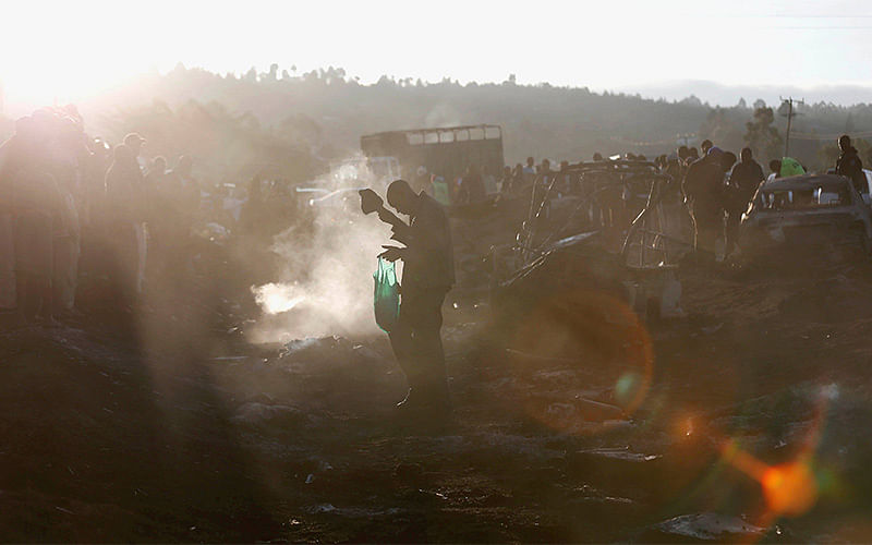 A man walks in the smoke as they assess the wreckages of cars burnt after a fireball from an tanker engulfed several vehicles and killed several people, near the Rift Valley town of Naivasha, west of Kenya`s capital Nairobi, December 11, 2016. Photo:Reuters