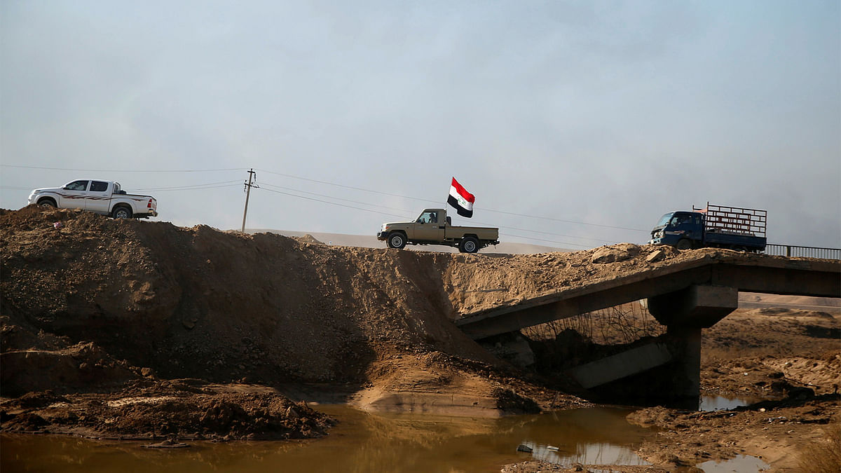 Vehicles pass by a destroyed bridge near Al Qayyara, south of Mosul, Iraq December 11, 2016. Photo: Reuters