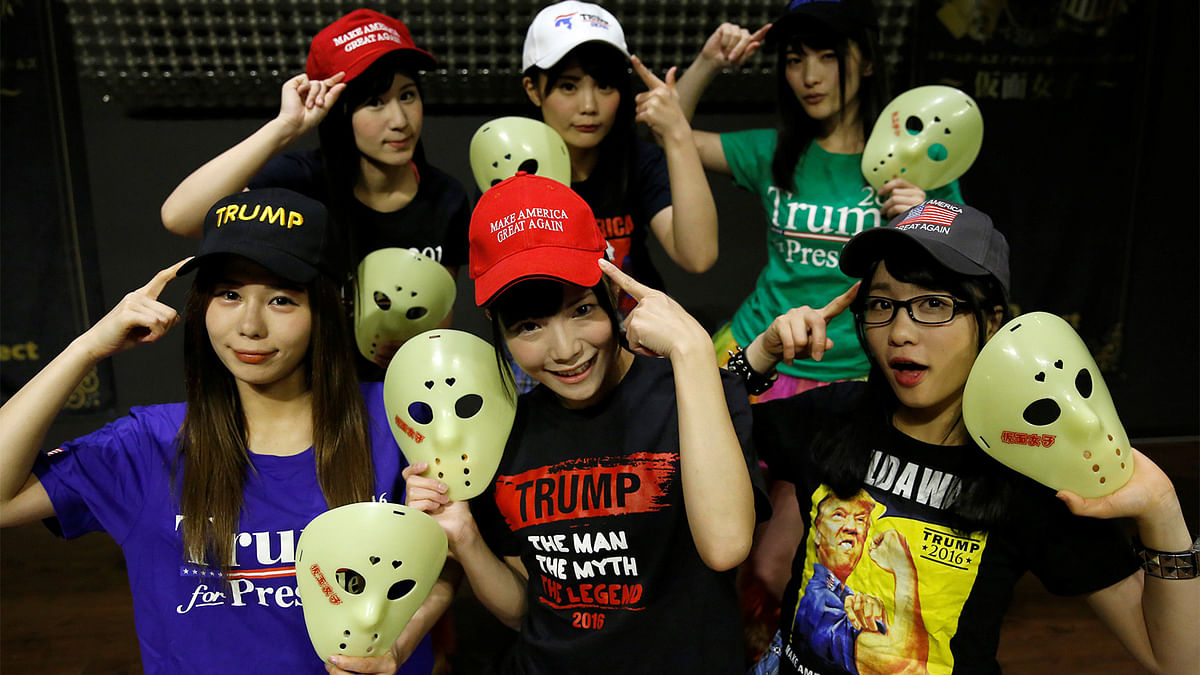 Members of Japanese idol group Kamen Joshi (Masked Girls) in attires featuring images or names of U.S. President-elect Donald Trump, pose for a photo after a rehearsal for a concert at their theatre in Tokyo`s Akihabara district, Japan, December 12, 2016. Photo: Reuters