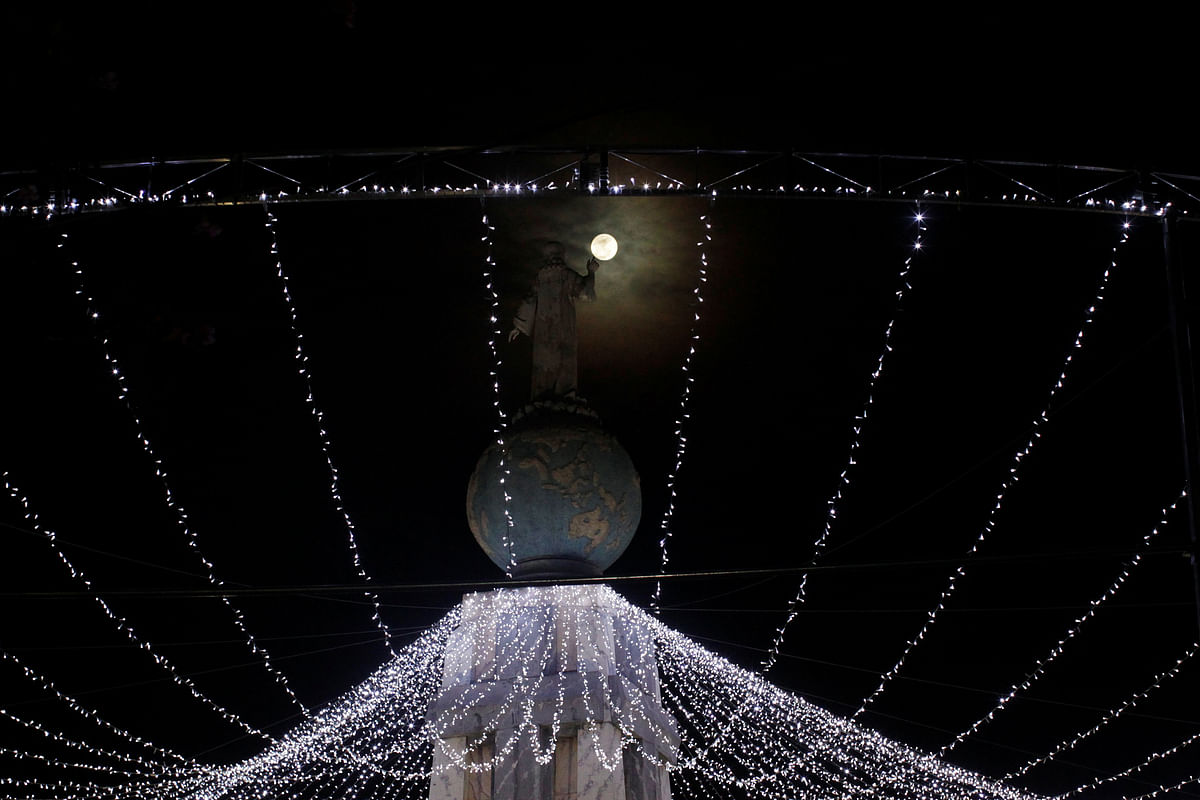 A full moon is seen near the Savior of the World monument in San Salvador, El Salvador. Photo: Reuters