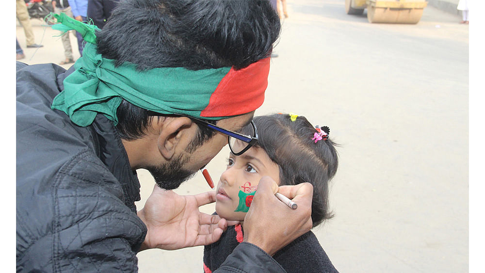 An artist draw a tattoo on the face of a child on the occasion of celebrate the 46th Victory Day on Friday.
