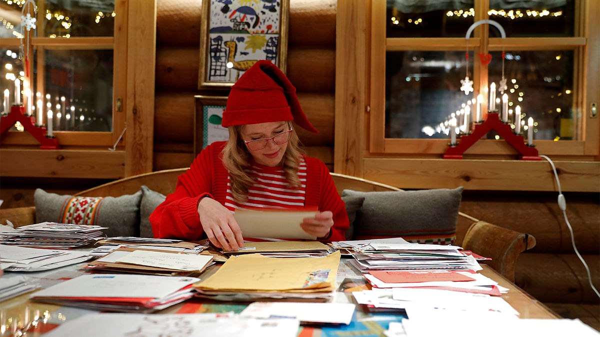 Elina, dressed as a Christmas elf, reads letters from around the world which were sent to Santa Claus at the Santa Claus` Post Office, in the Arctic Circle near Rovaniemi, Finland. Photo: Reuters