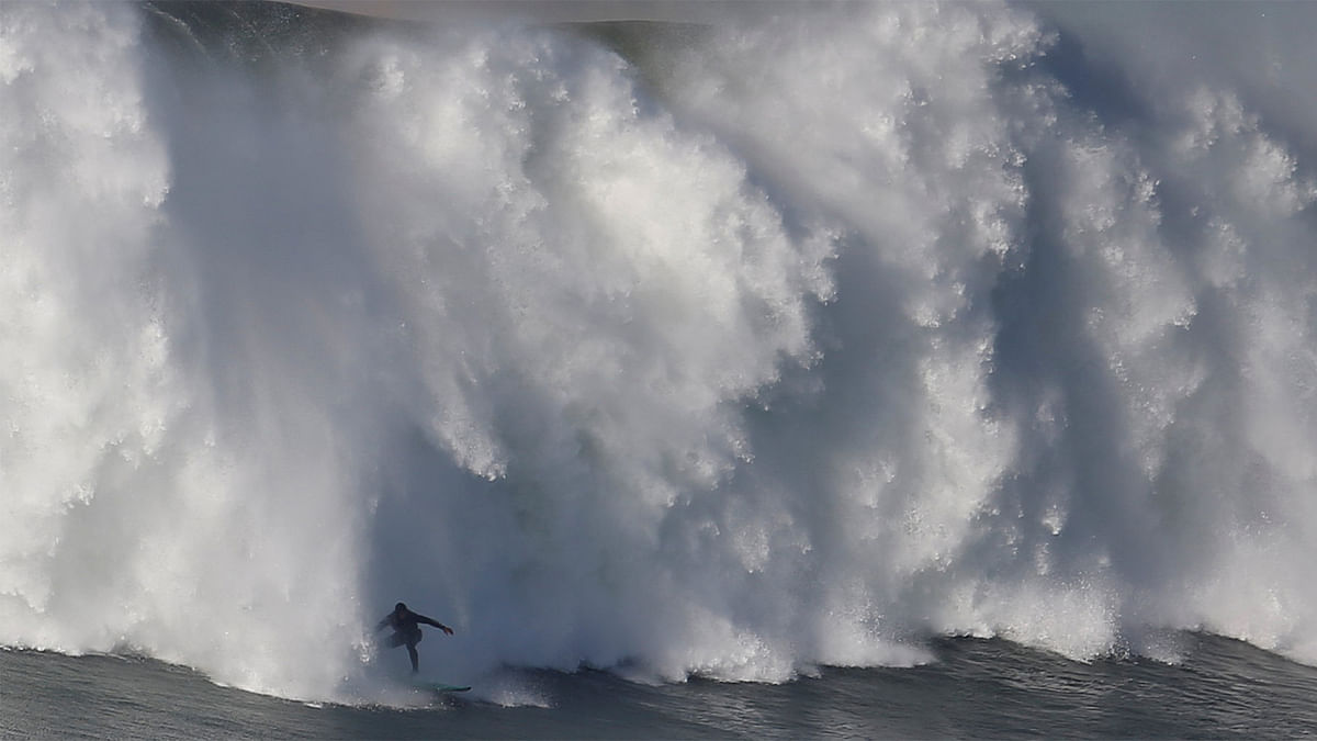 Portuguese surfer Alex Botelho drops in on a large wave at Praia do Norte in Nazare, Portugal December 17, 2016. Reuters