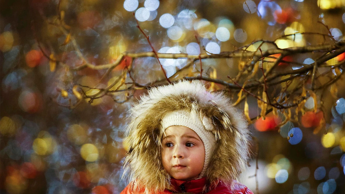 A girl stands under a tree decorated for the New Year and Christmas season at Red Square in Moscow, Russia December 17, 2016. Picture taken December 17, 2016. Reuters