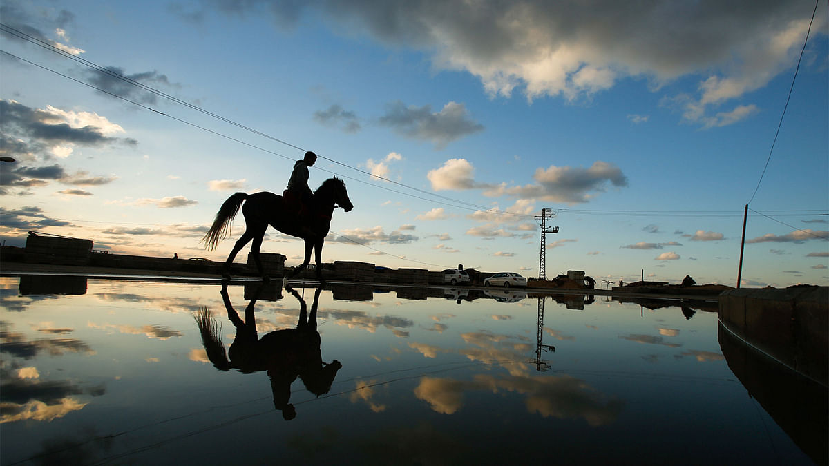 A Palestinian rides a horse along a flooded path in the northern of Gaza Strip December 17, 2016. Reuters