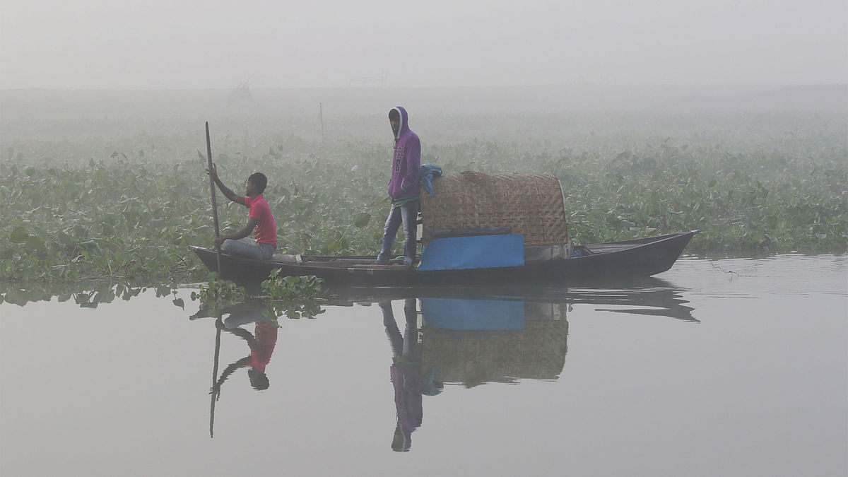 Two men on a boat going for fishing in Ichhamati River in the winter morning. Photo: Saiful Islam