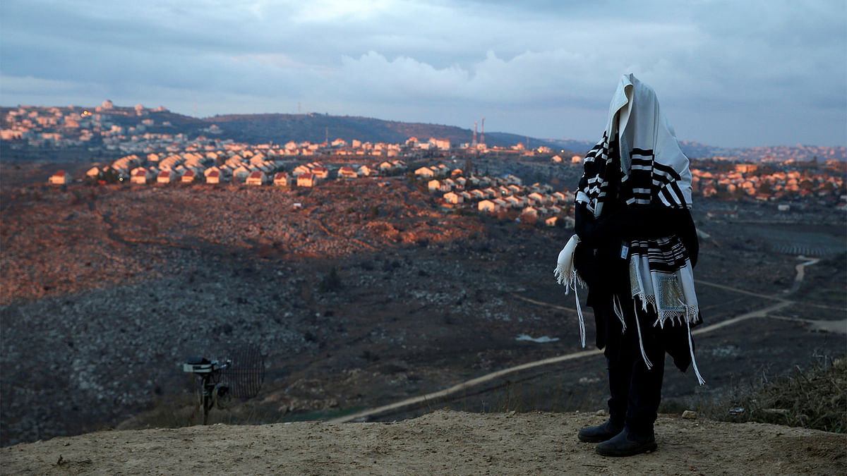A Jewish man covered in a prayer shawl, prays in the Jewish settler outpost of Amona in the West Bank December 18, 2016. Photo: Reuters