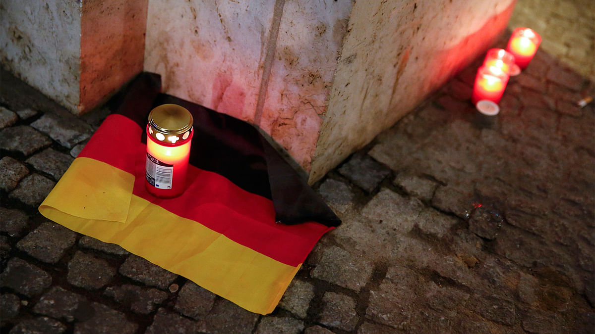 A candle is burning on a German national flag near the site where a truck ploughed through a crowd at a Berlin Christmas market. Photo: Reuters