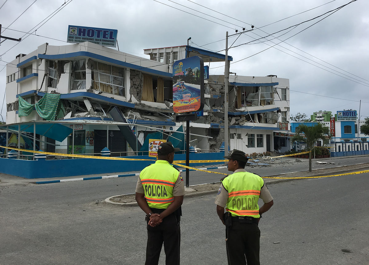 Police officers stand near a damaged building after a 5.8-magnitude earthquake shook Ecuador`s Pacific coast early on Monday, in Atacames. Photo: Reuters