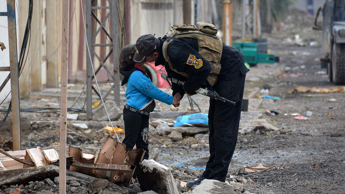 A member of Iraqi special forces kisses a child in the neighbourhood of al-Barid east of Mosul, during their ongoing operation against Islamic State (IS) group jihadists to wrest back the city. Photo: AFP