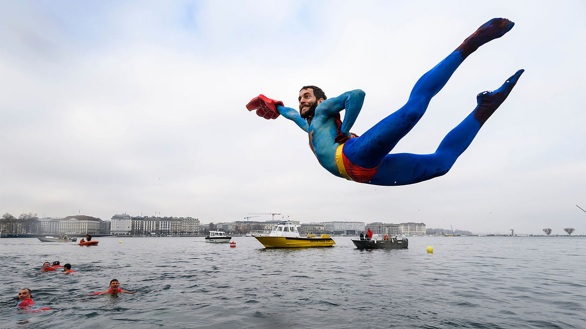 A swimmer disguised as Superman dives into the lake during the 78th `Coupe de Noel` (Christmas cup) swimming race in the Lake Geneva, Geneva. Photo: AFP
