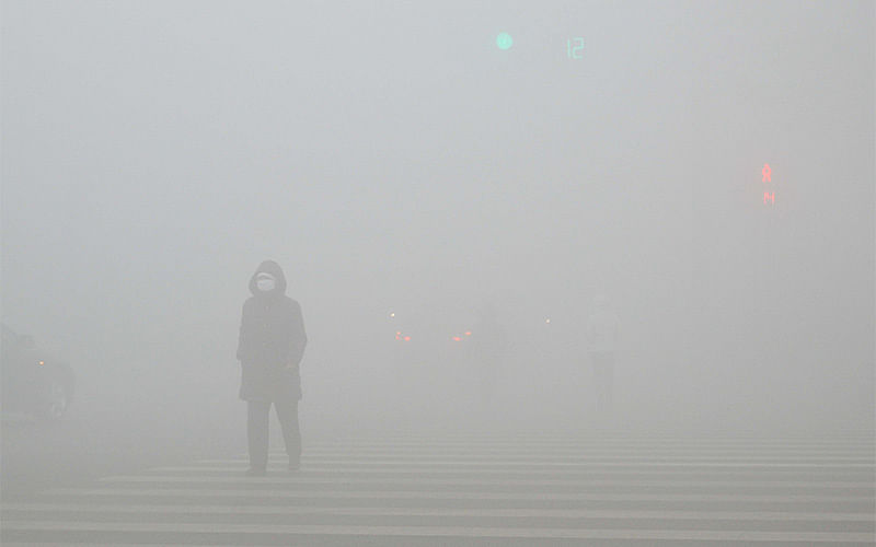 People walk past a street in heavy smog during a polluted day in Weifang, Shandong province, December 20, 2016. Photo: Reuters