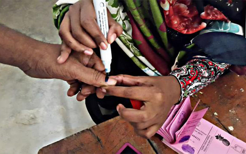 A presiding officer applies voting ink on a voter`s finger at Sanarpara Government Primary School in Narayanganj City Corporation elections on 22 December, 2017. Photo: Prothom Alo