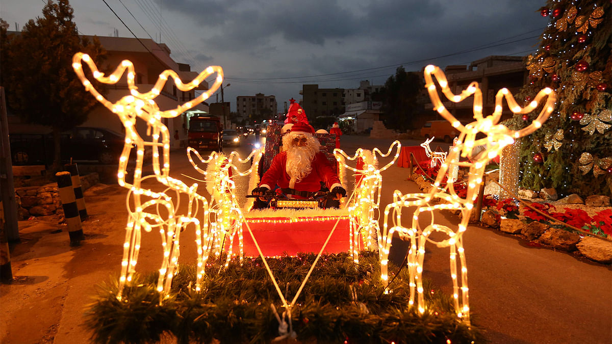 A man dressed as Santa Claus rides a Christmas decorated vehicle in Jiyeh, south Lebanon December 23, 2016. Photo: Reuters