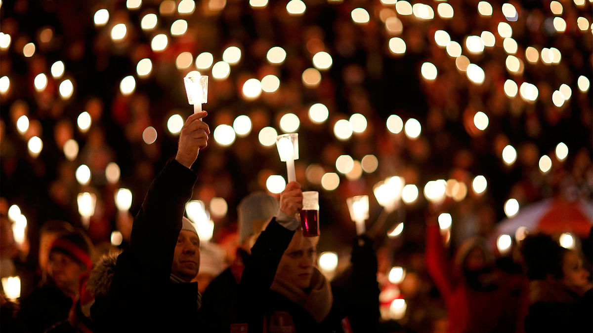 People observe a minute`s silence for victims after a truck ploughed into a crowd at a market on Monday night, as they attend the Weihnachtssingen, a candle-lit carol concert with fans of the second-division club FC Union Berlin at the Alte Foersterei stadium in Berlin, Germany, December 23, 2016. Photo: Reuters