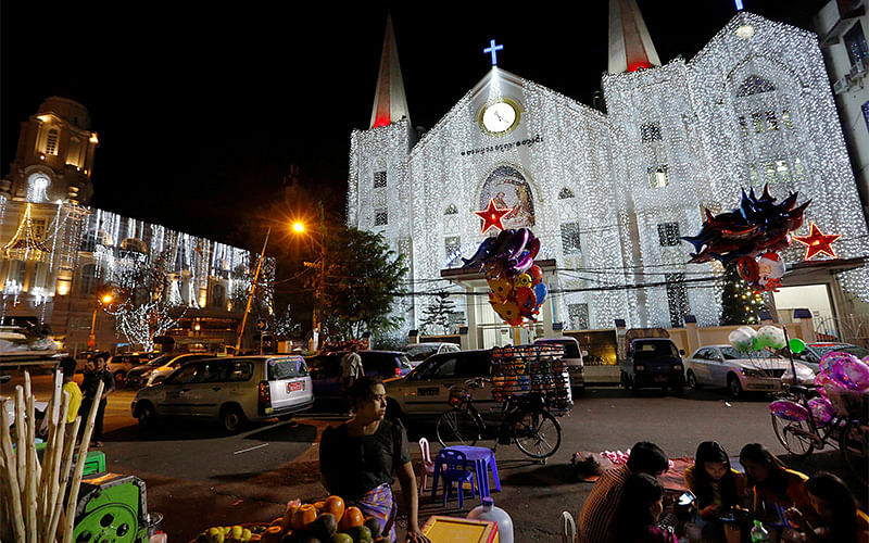 A vendor sells fruits in front of Emmanuel Baptist church as people visit for a ceremony on Christmas eve in Yangon. Photo: Reuters