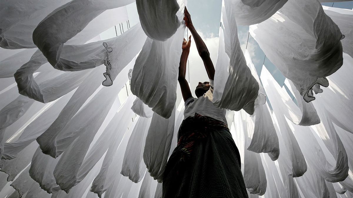 A dye factory worker suns fabric after washing them in Narayanganj near Dhaka, Bangladesh. REUTERS
