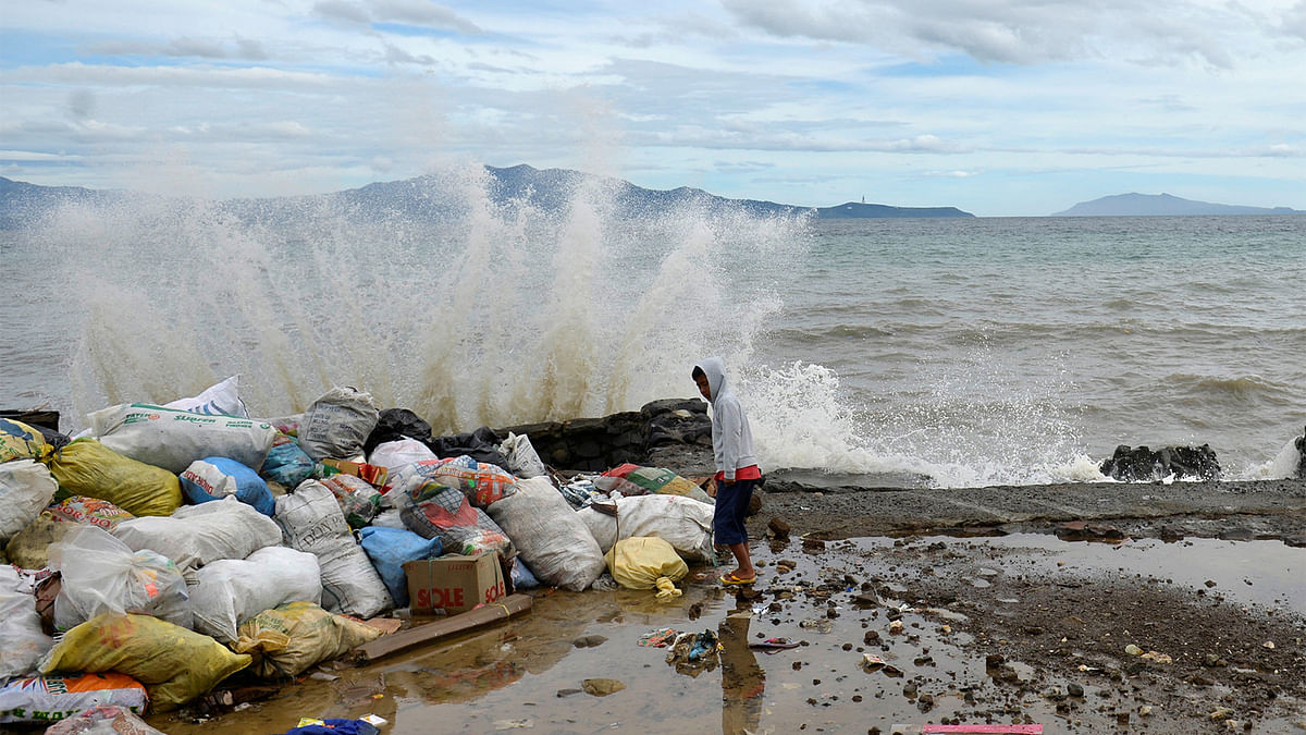 A boy stands at a partially damaged port, as strong waves hit the shore after Typhoon Nock-Ten hit Mabini, Batangas, in the Philippines December 26, 2016. Photo: Reuters