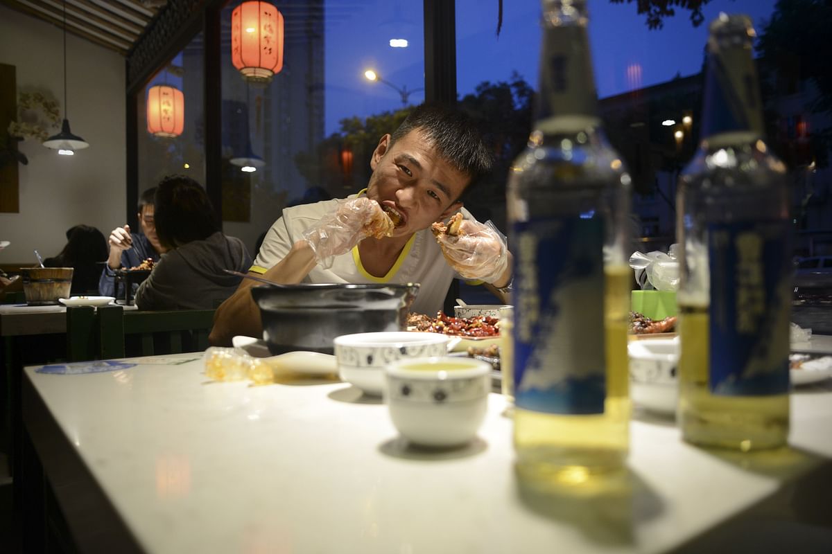 This picture taken on September 8, 2016 shows a man eating a rabbit head at a restaurant in Chengdu, in southwestern China`s Sichuan province. Photo: AFP