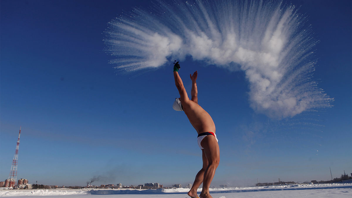 A winter swim lover throws hot water into cold air in Heihe, Heilongjiang province, China, December 27, 2016. Photo: Reuters